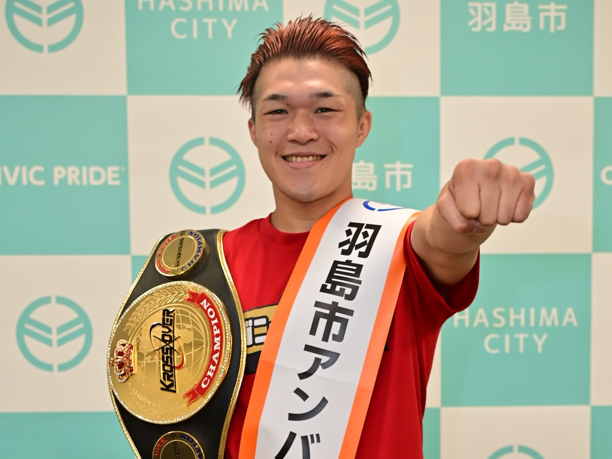 羽島市アンバサダーのたすきを掛け、ベルトを持つゴングマン